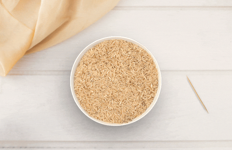 Arroz integral coberto com plástico-filme, furado com palito de dentes