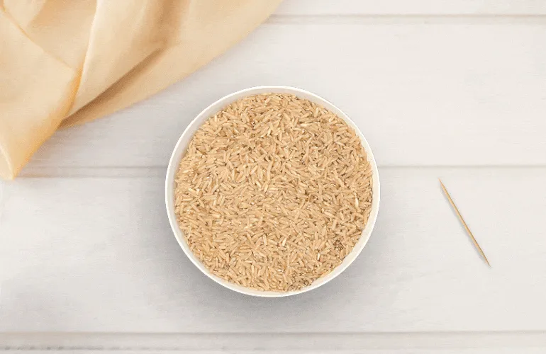 Arroz integral coberto com plástico-filme, furado com palito de dentes
