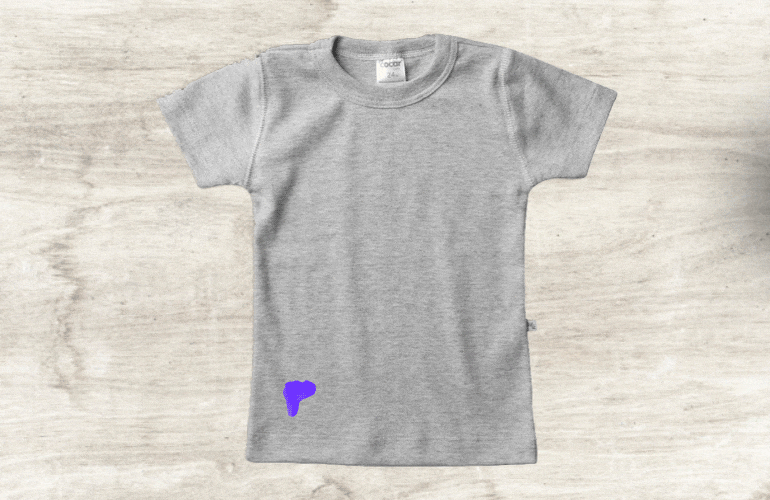 Algodão com removedor sendo colocado sobre mancha de esmalte na camiseta