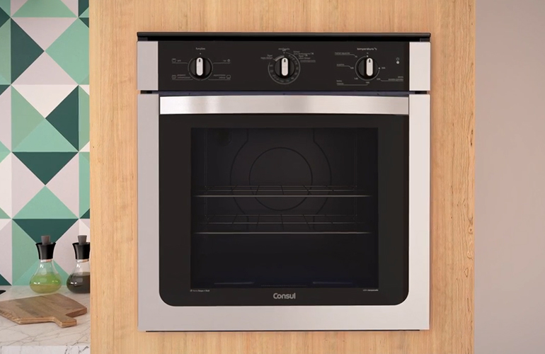 Forno de embutir a gás preto com detalhes prateado.
