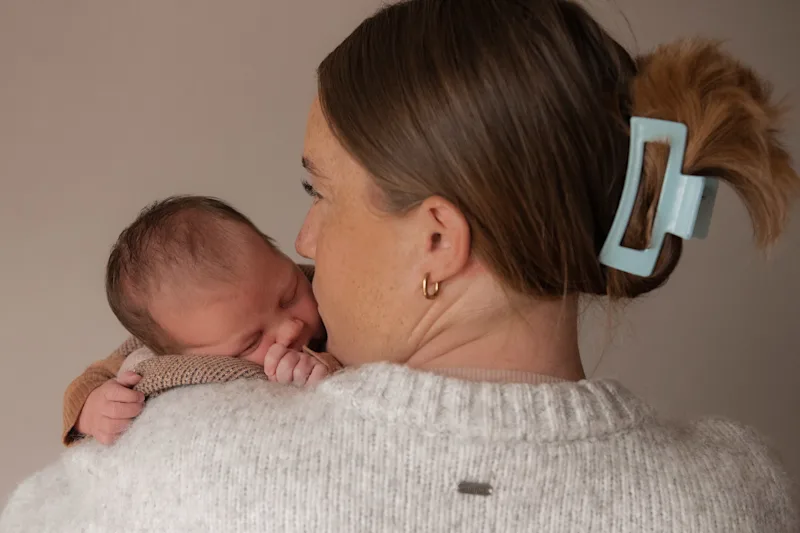 A newborn baby held close during a Launceston newborn session