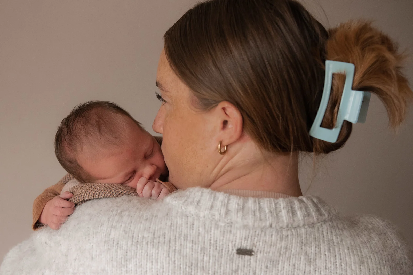 A newborn baby held close during a Launceston newborn session