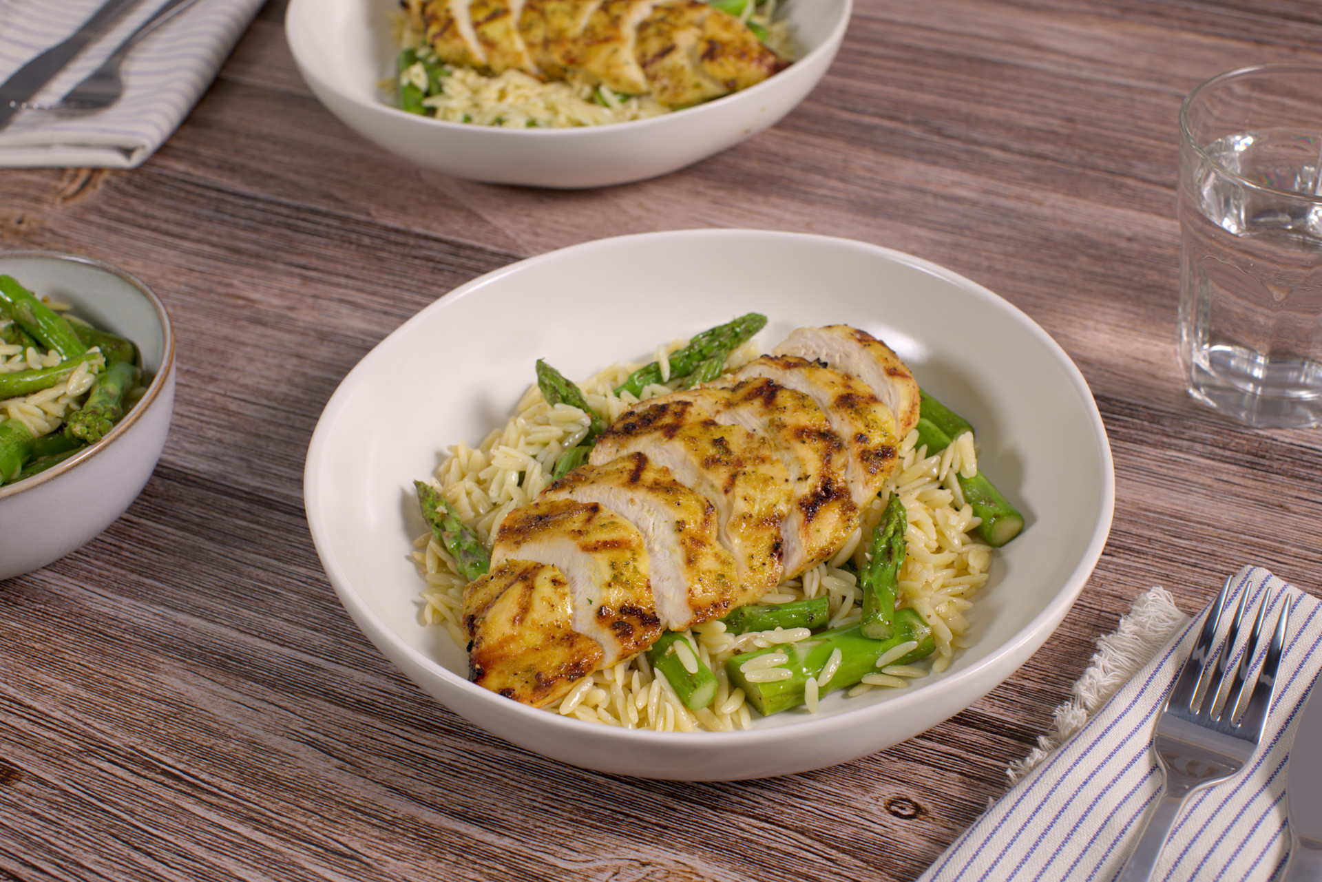 Grilled Chicken & Asparagus Orzo in a white bowl