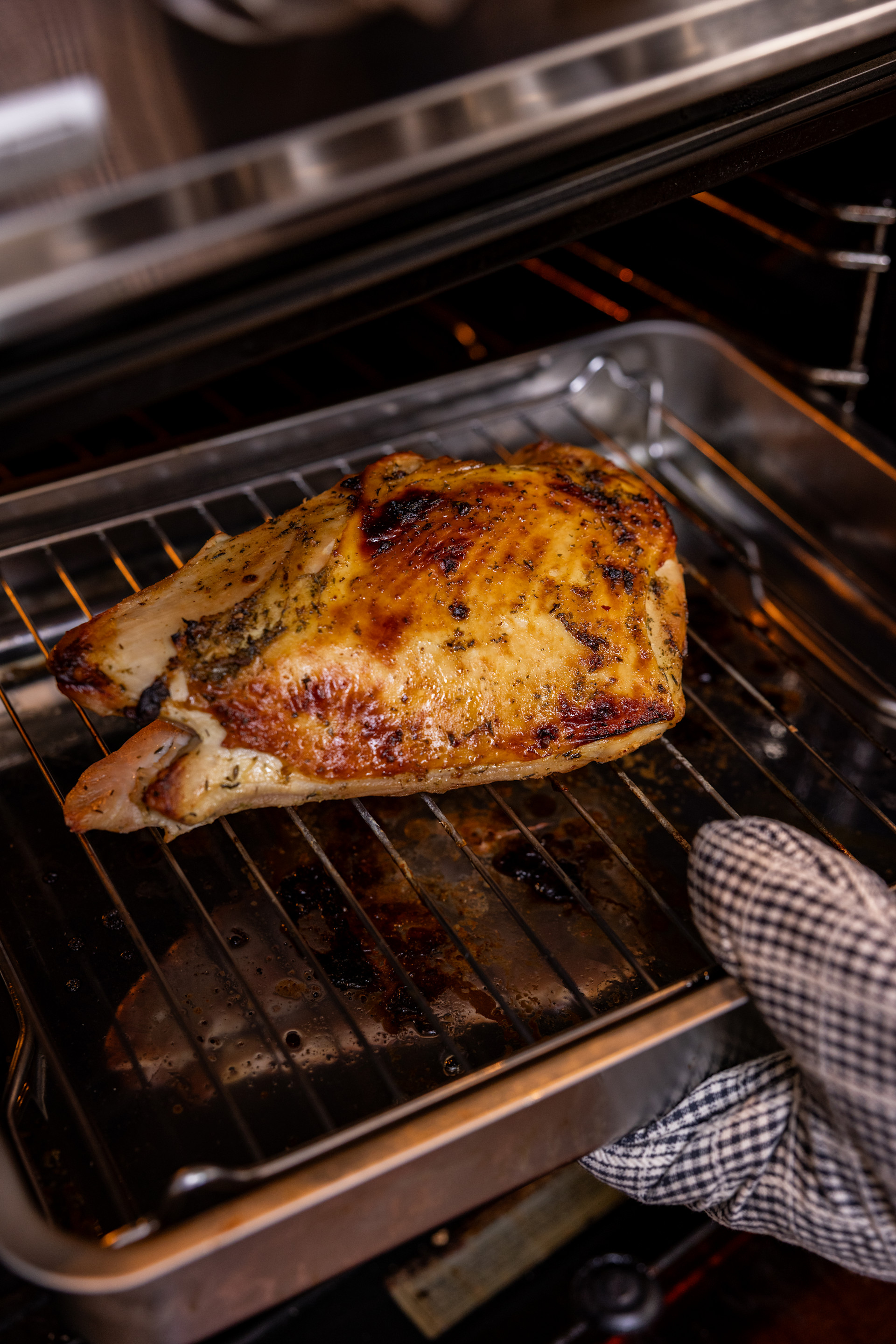 turkey breast on a baking pan being put into the oven