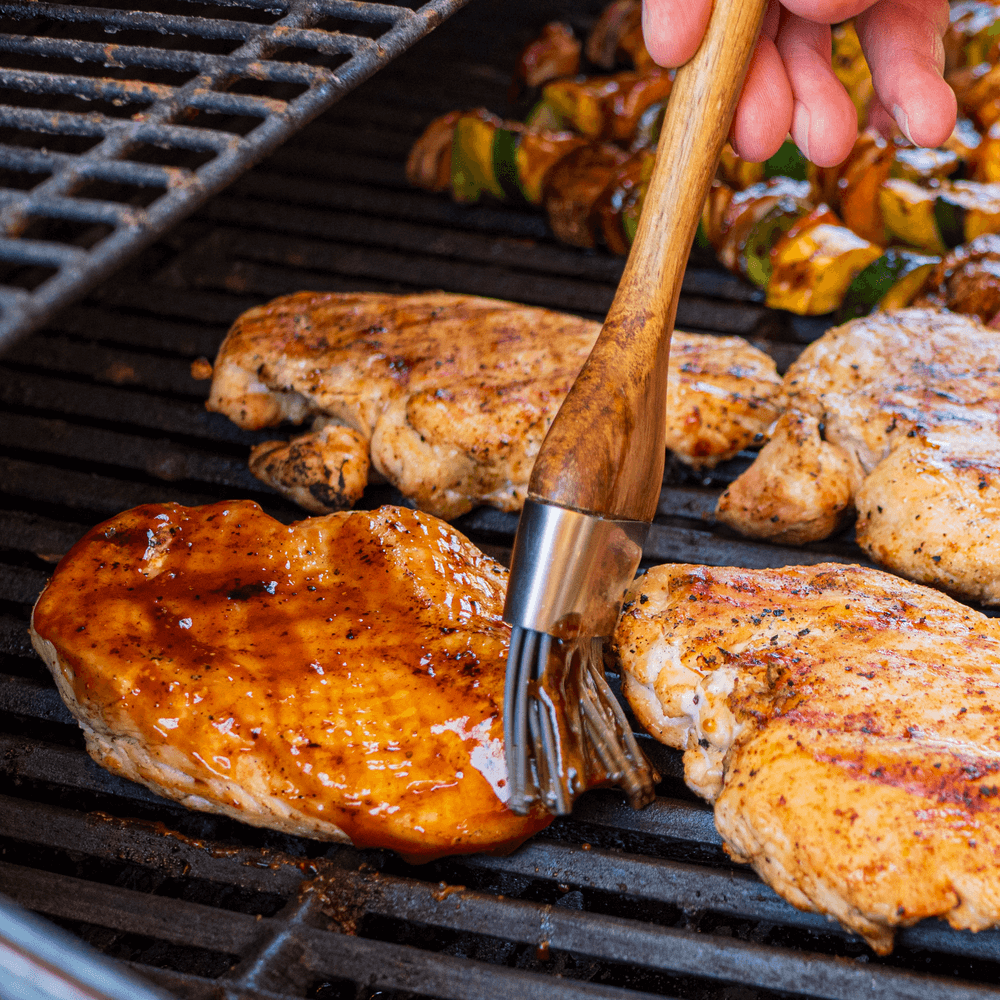 Chicken breasts and thighs on the grill with bbq sauce