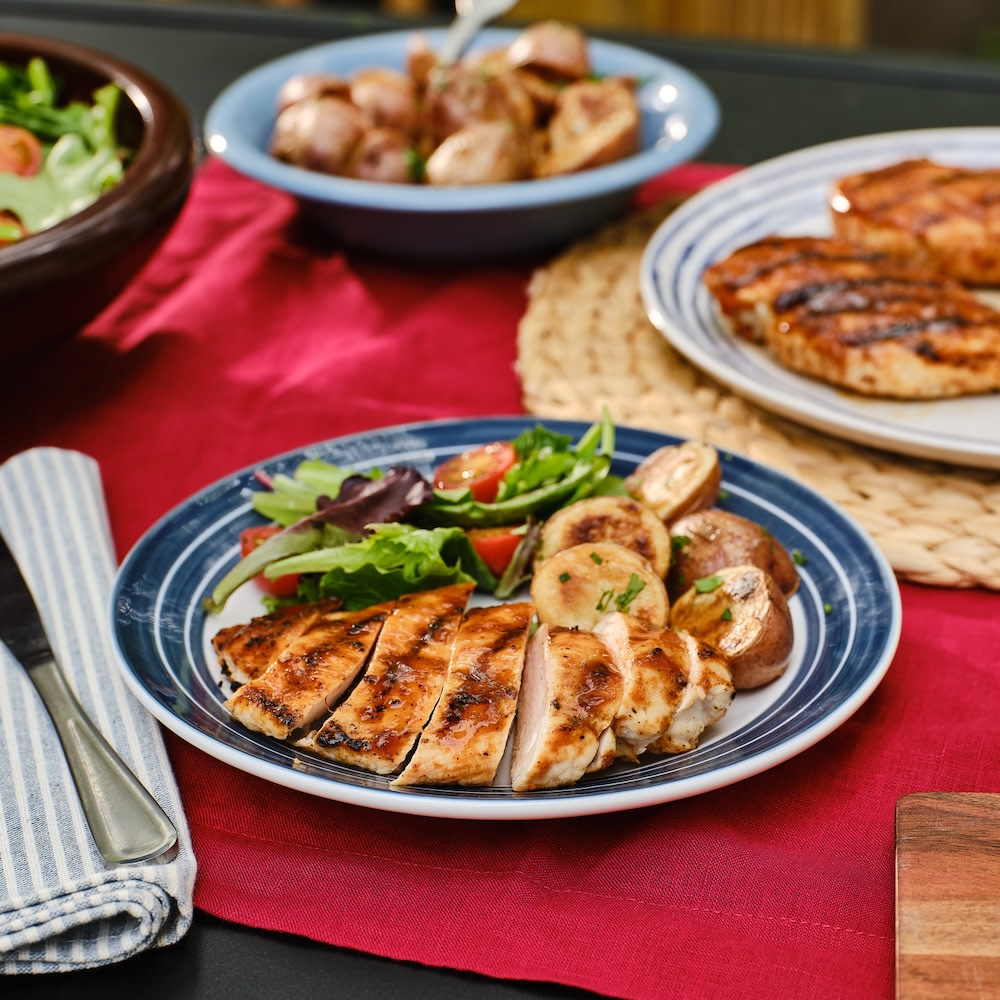 Sliced grilled chicken breast with potatoes and salad