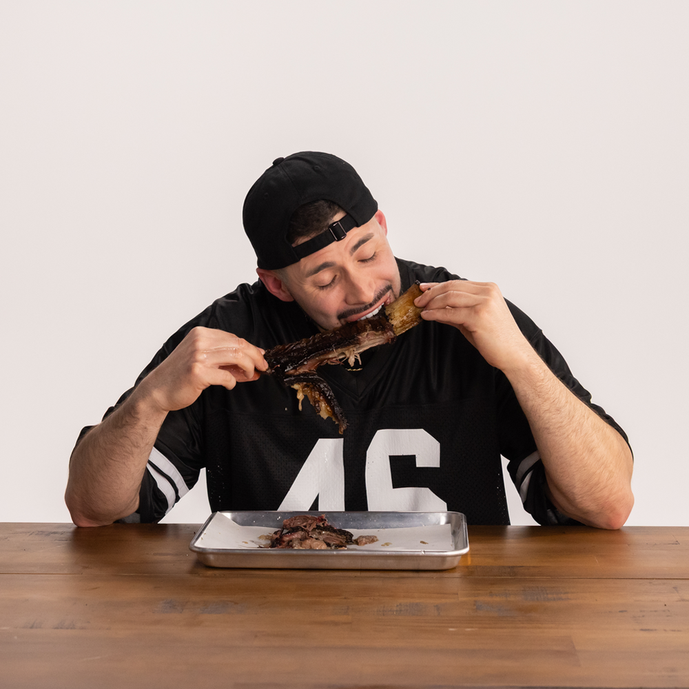 Still image of man in jersey eating a rib