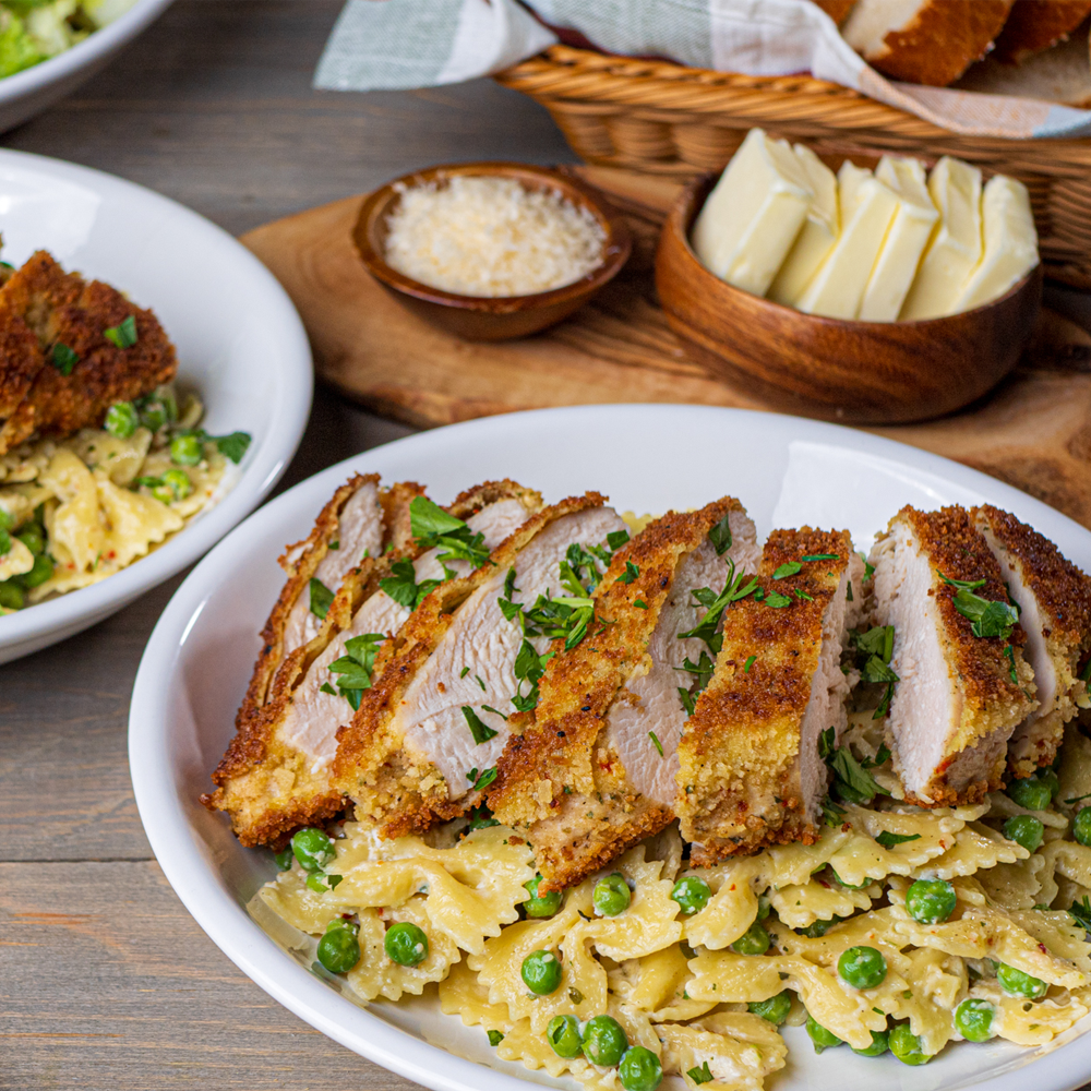 Crispy breaded chicken sliced on bowtie pasta with peas