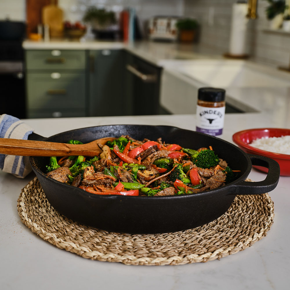 Beef and vegetable stir fry in cast iron skillet on counter