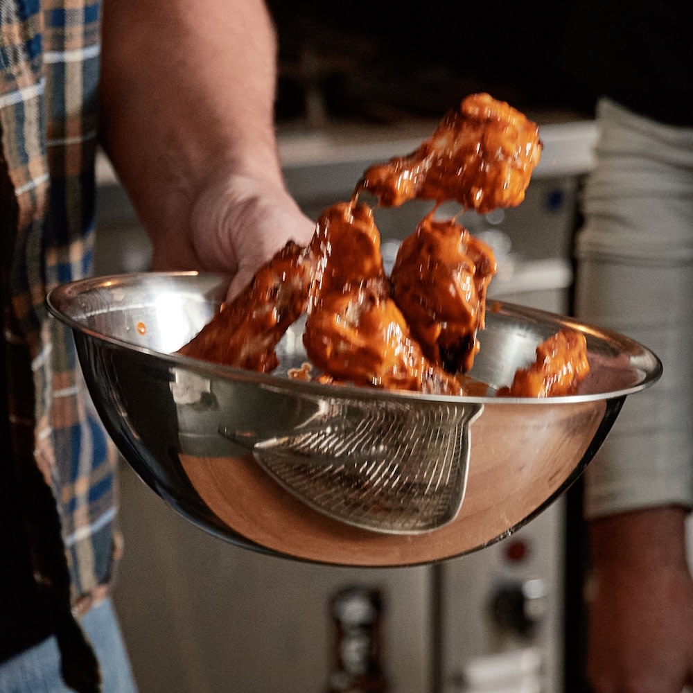 Wings being tossed in sauce