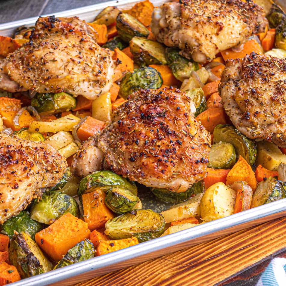 Sheet pan with seasoned chicken thighs and fall vegetables
