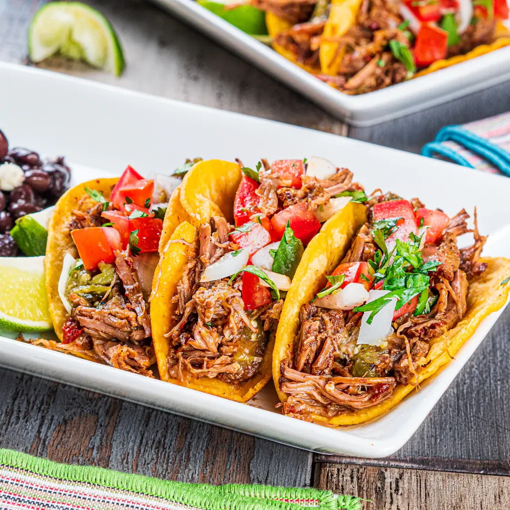 Three barbacoa tacos on a plate