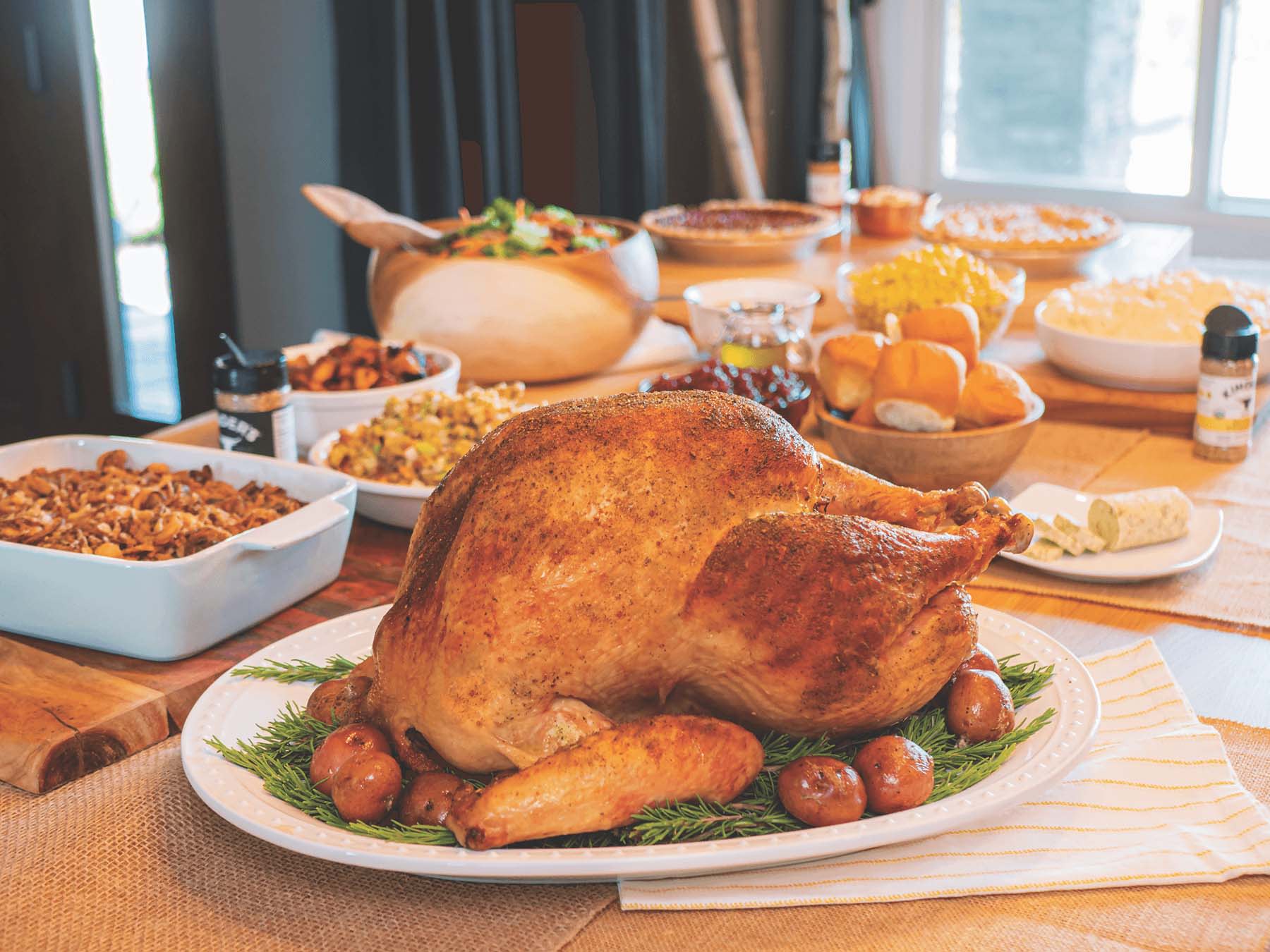 Deep fried whole turkey on thanksgiving table with other dishes