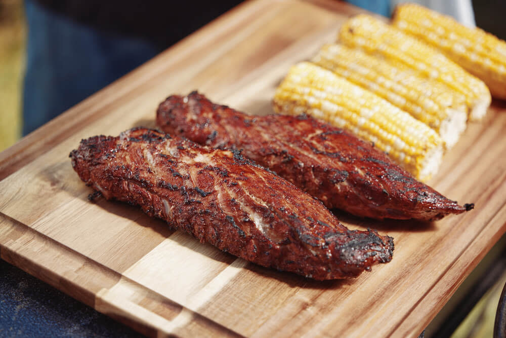 Grilled pork tenderloin resting on cutting board