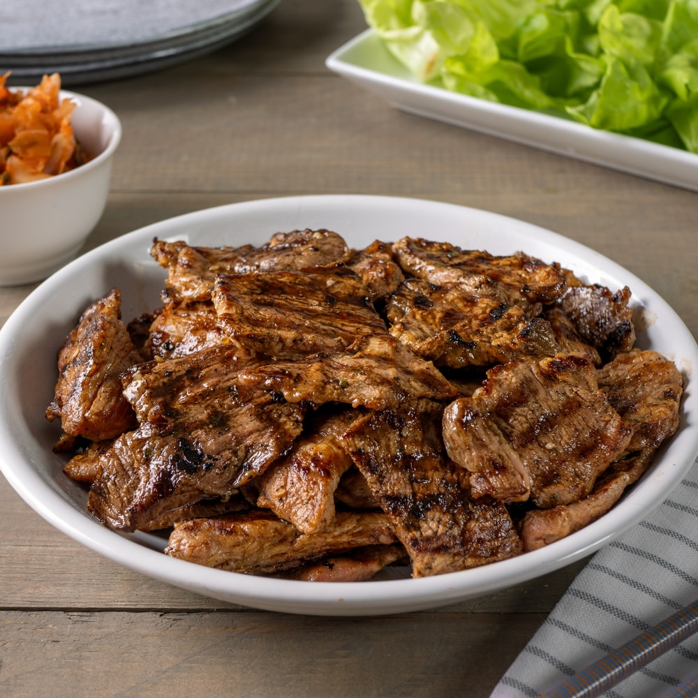 Korean BBQ pork shoulder bites on a white serving plate