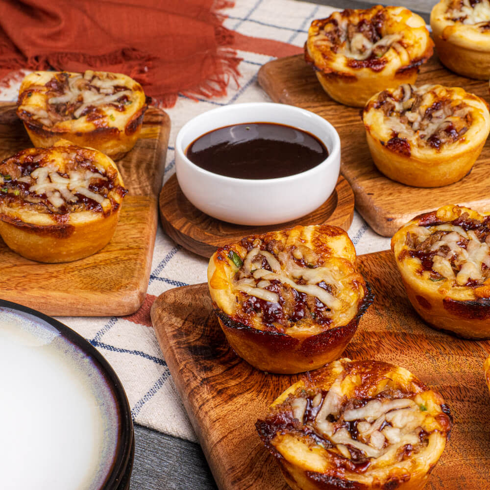 Baked savory pulled pork cupcakes on a cutting board with sauce