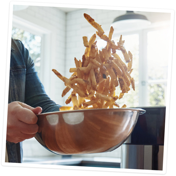 Tossing fries with Liquid Gold sauce