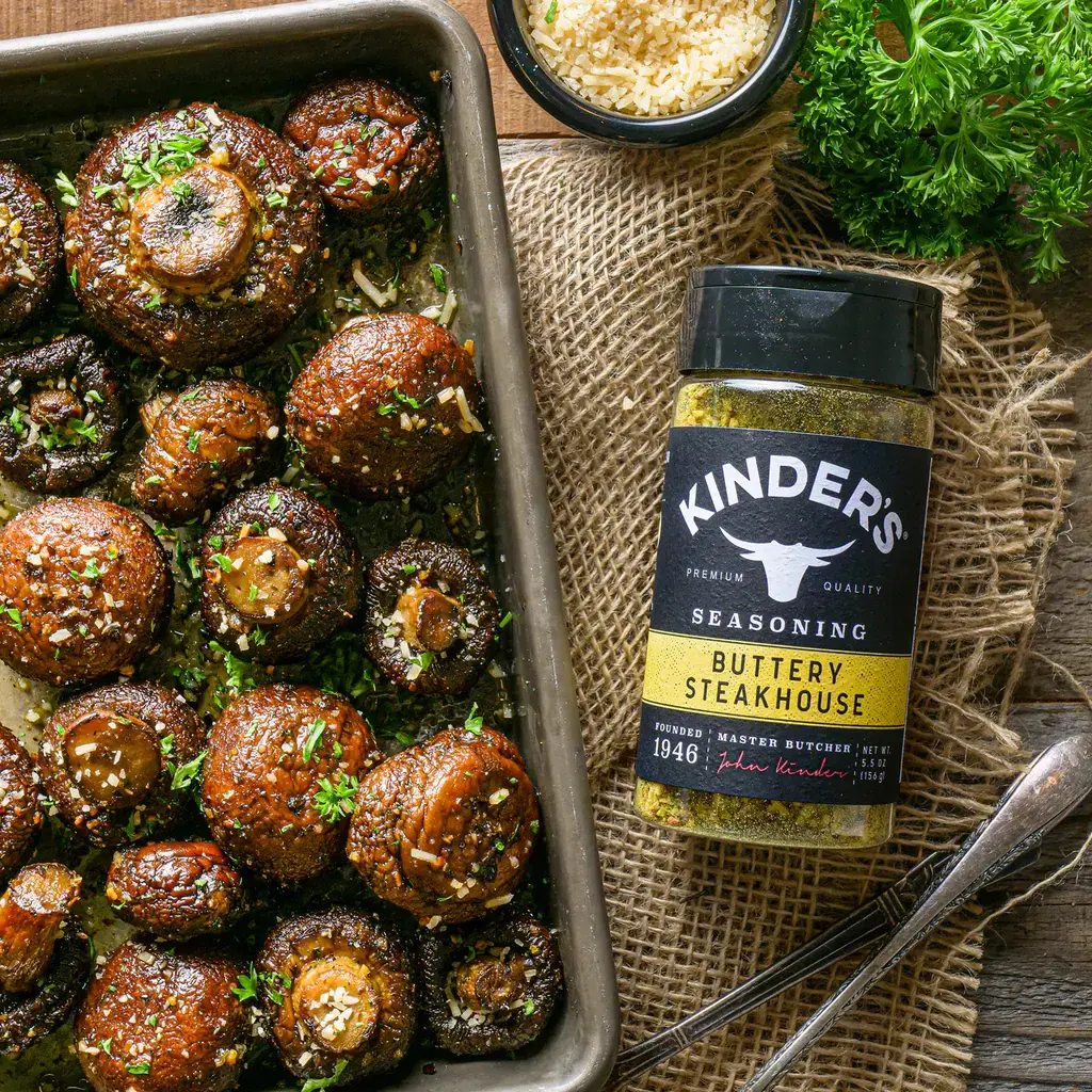 Pan of roasted seasoned mushrooms with bottle of kinder's buttery steakhouse seasoning