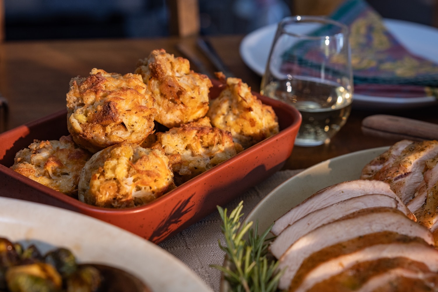 stuffing muffins in a red serving dish on a thanksgiving table