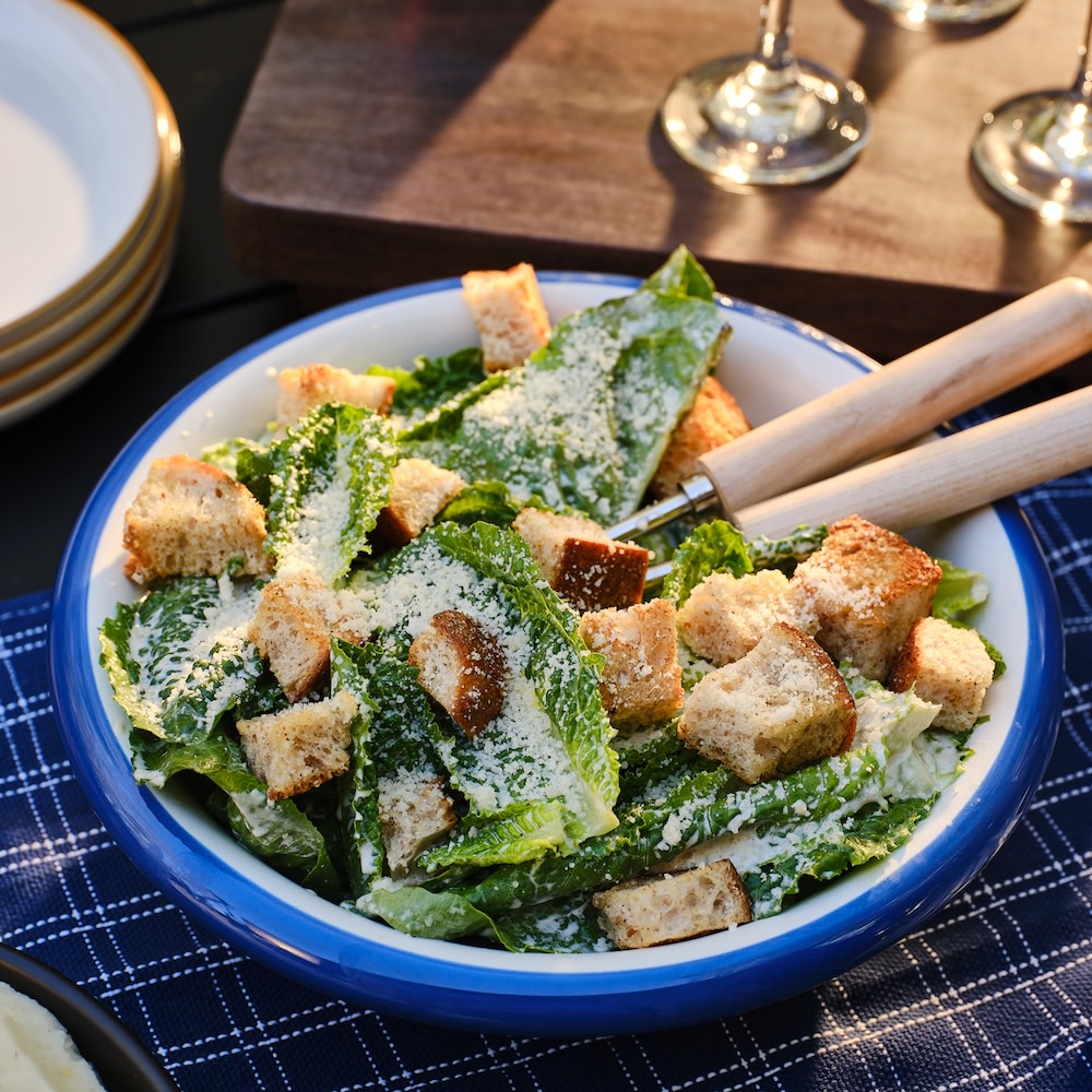 Homemade croutons in a Ceasar Salad on a picnic table 