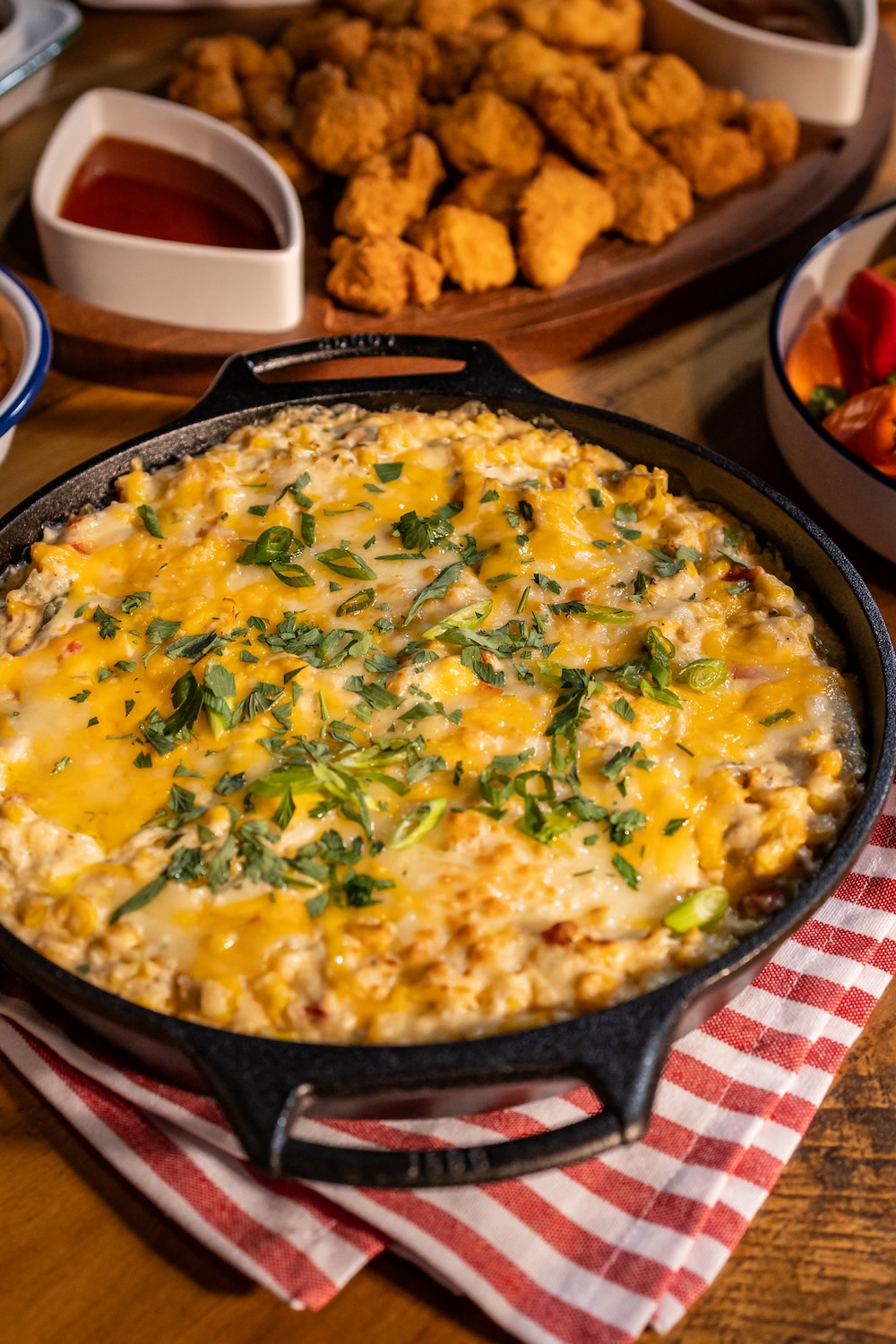 Buffalo chicken dip in a cast iron skillet on a red and white cloth