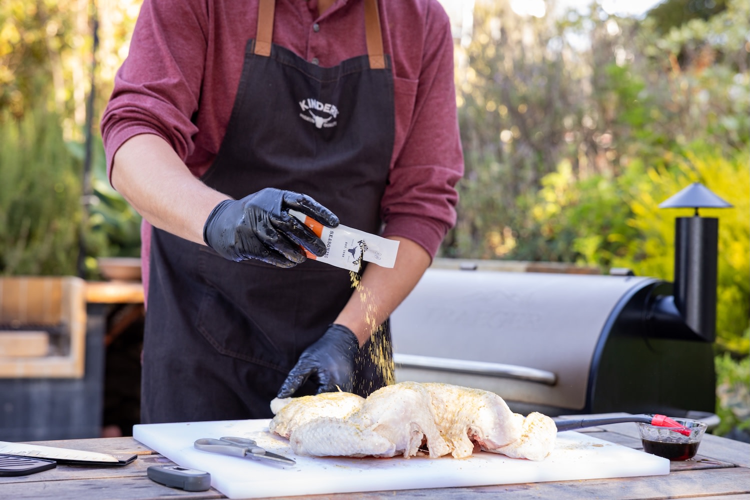 man seasoning a whole turkey on a white cutting board
