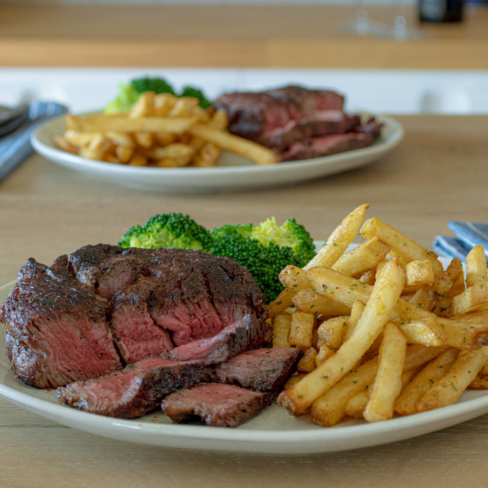 Grilled ribeye cap on a plate with asparagus