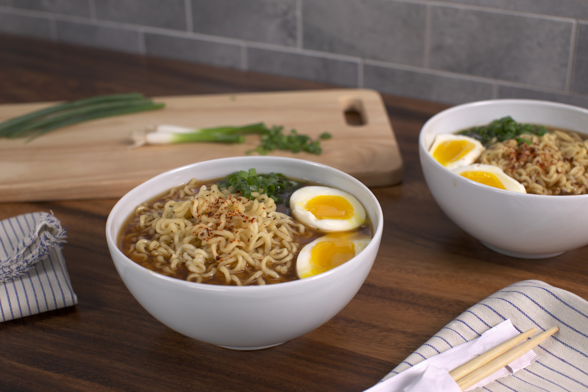 ramen in a white bowl with a soft-boiled egg and green onions