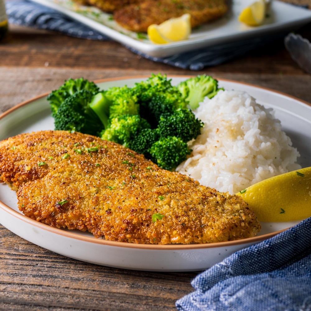 Chicken cutlets on a plate with broccoli and rice