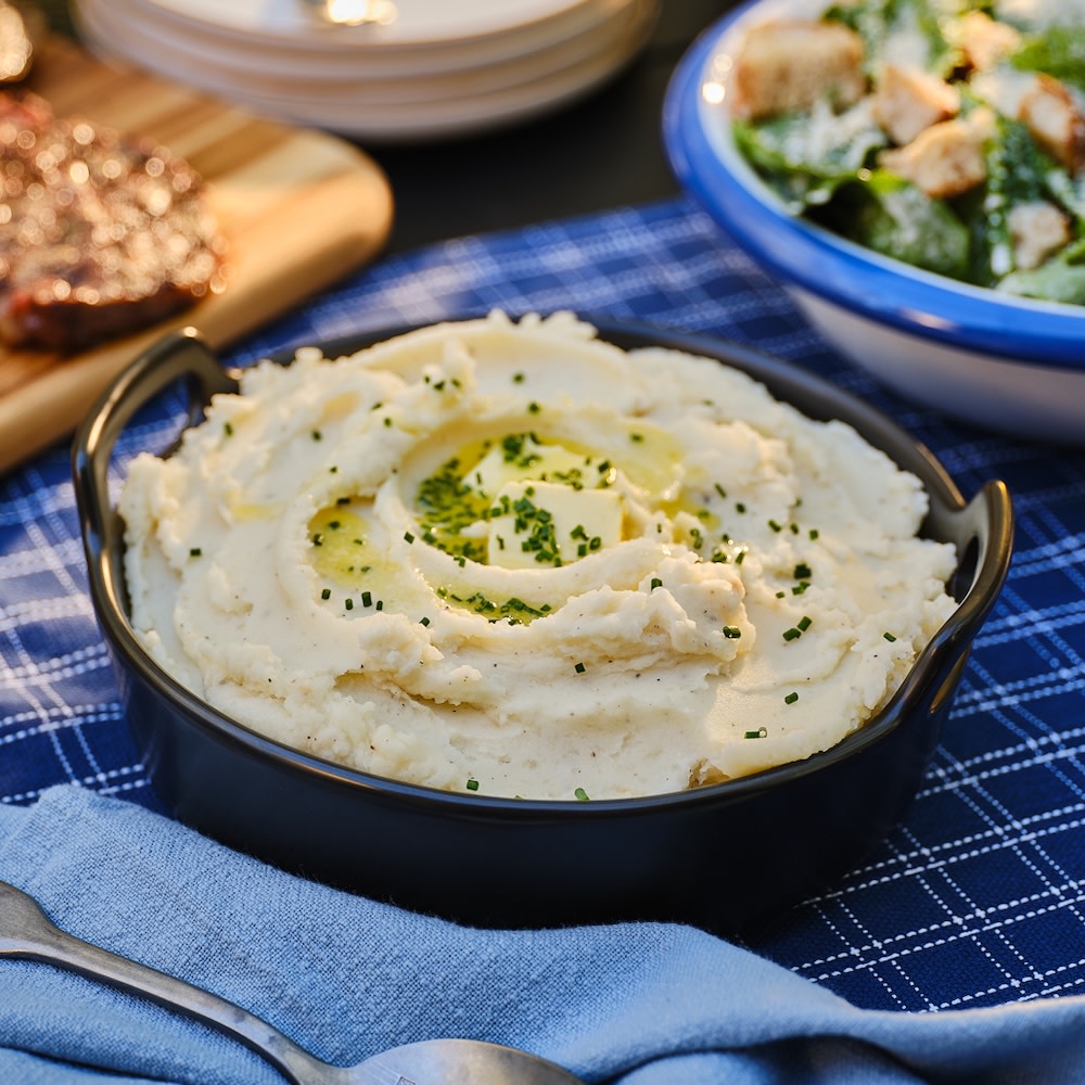 Steakhouse mashed potatoes on a table with a blue table cloth