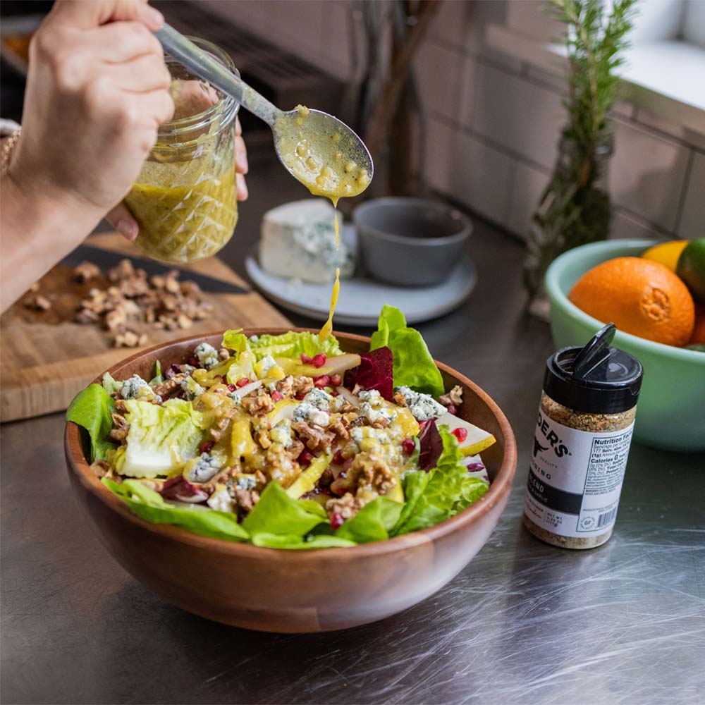 Homemade vinaigrette being spooned over a salad