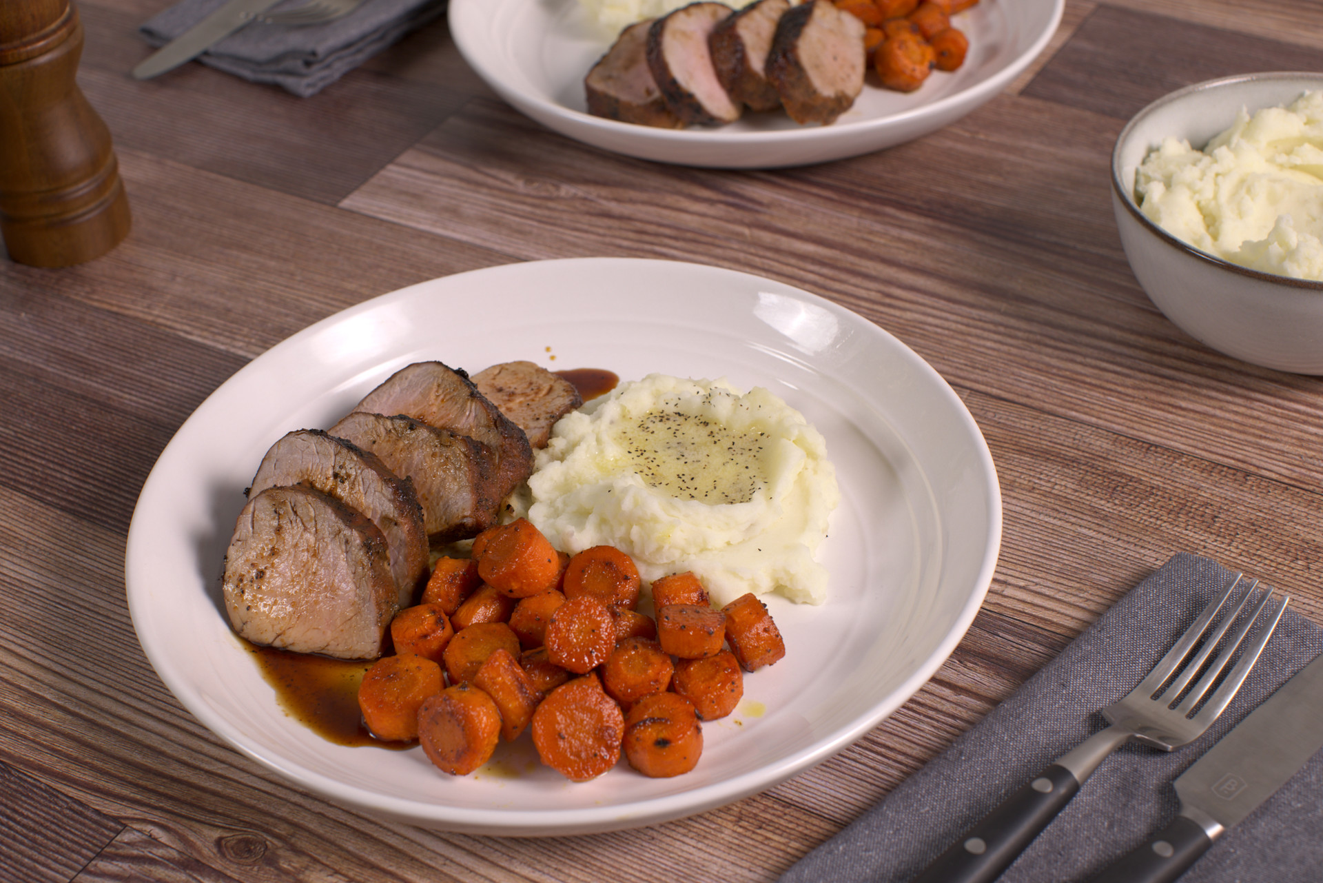 Grilled Pork Tenderloin with Glazed Carrots & Mashed Potatoes on a white plate