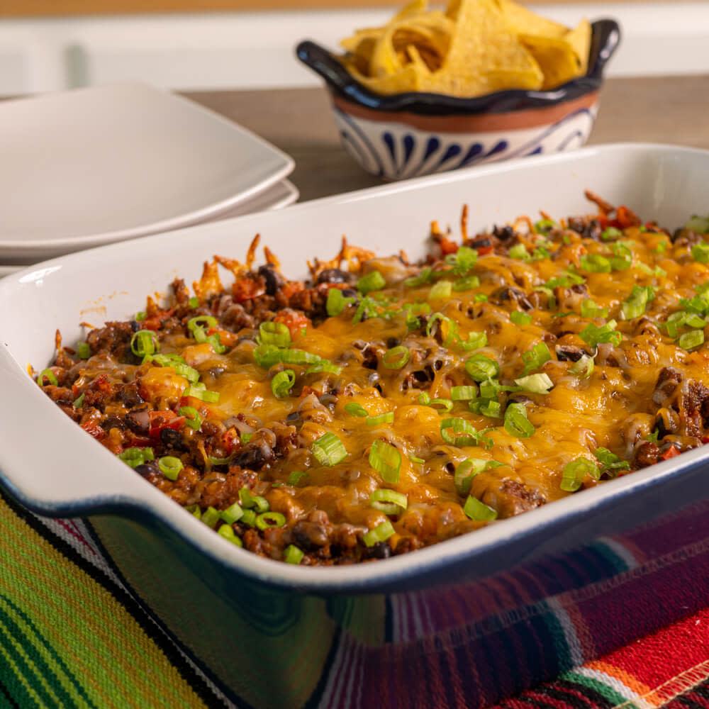 Casserole dish with cheese covered taco casserole inside