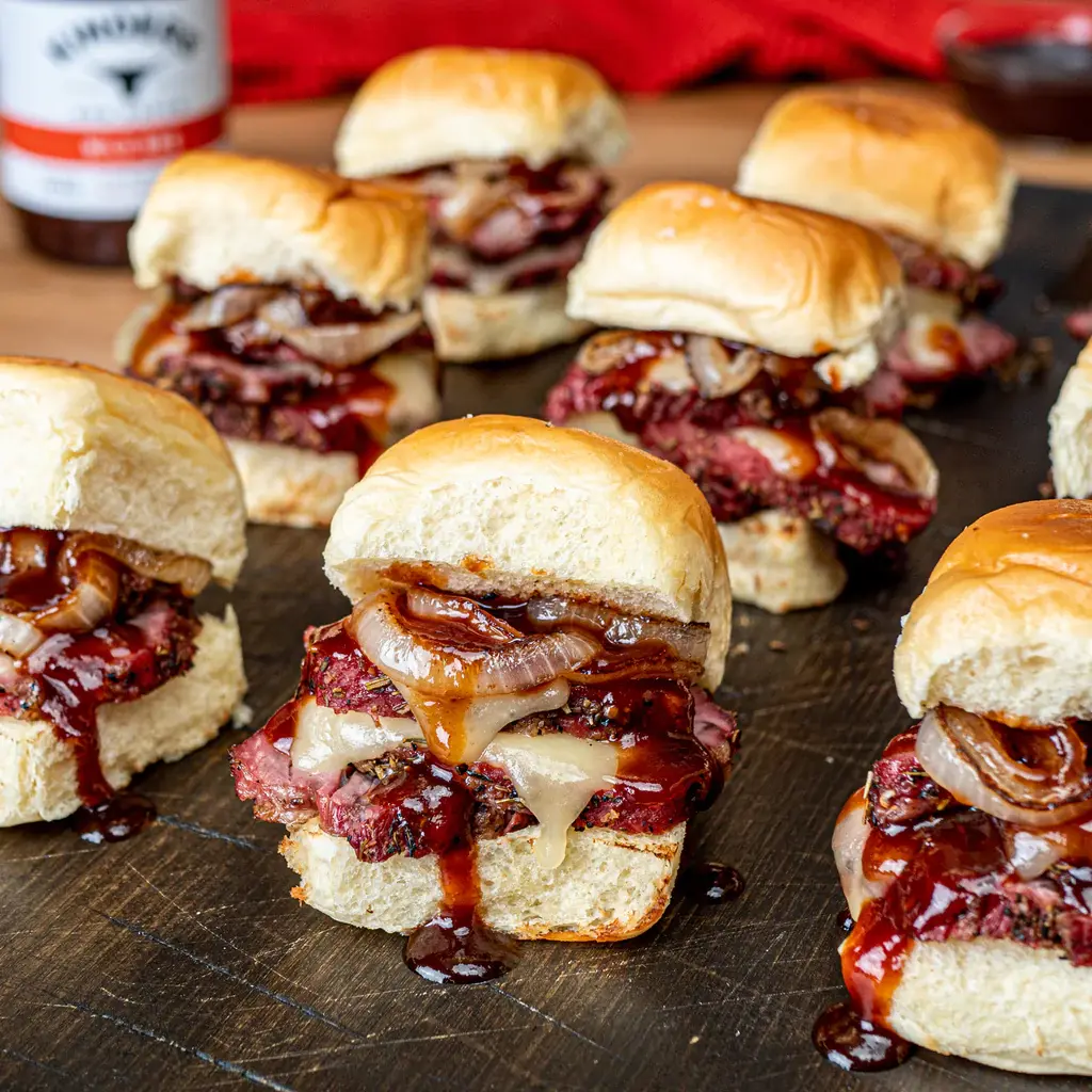 Sliders with sliced prime rib bbq sauce and cooked onions