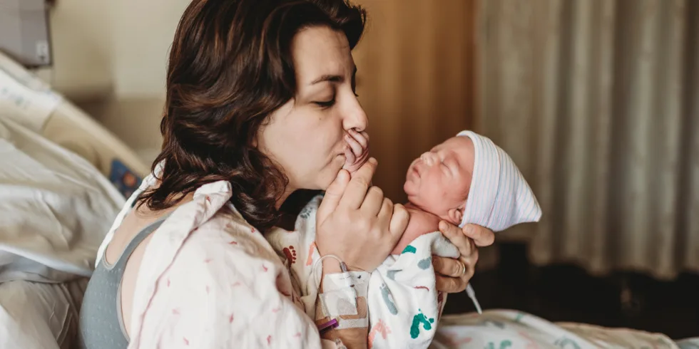 Woman with her newborn baby postpartum