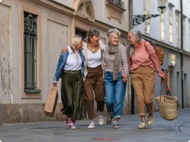 Women laughing and walking down the street on vacation