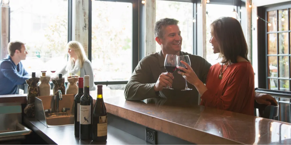 A couple at bar enjoying a glass of wine