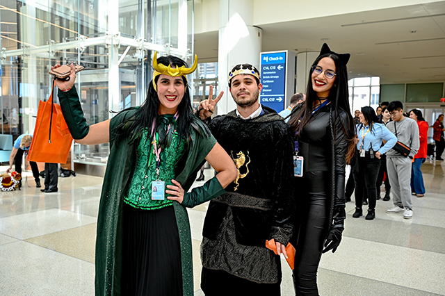 2025 Halloween at MCO photo of three people in costume. One person is dressed up as Loki, another as a king, and another as a cat.