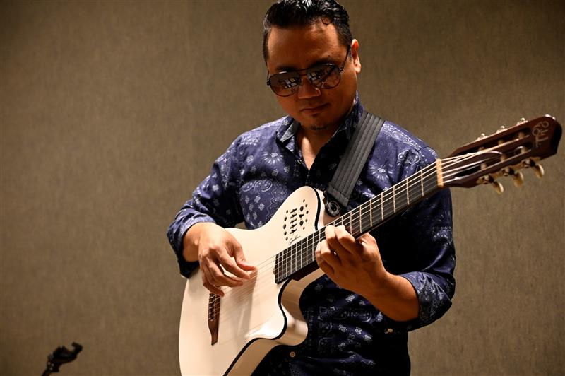 A man playing a guitar at MCO.