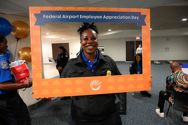 2025 Federal Airport Employee Appreciation Day photo of one federal TSA agent holding a large frame in front that says, "Federal Airport Employee Appreciate Day."
