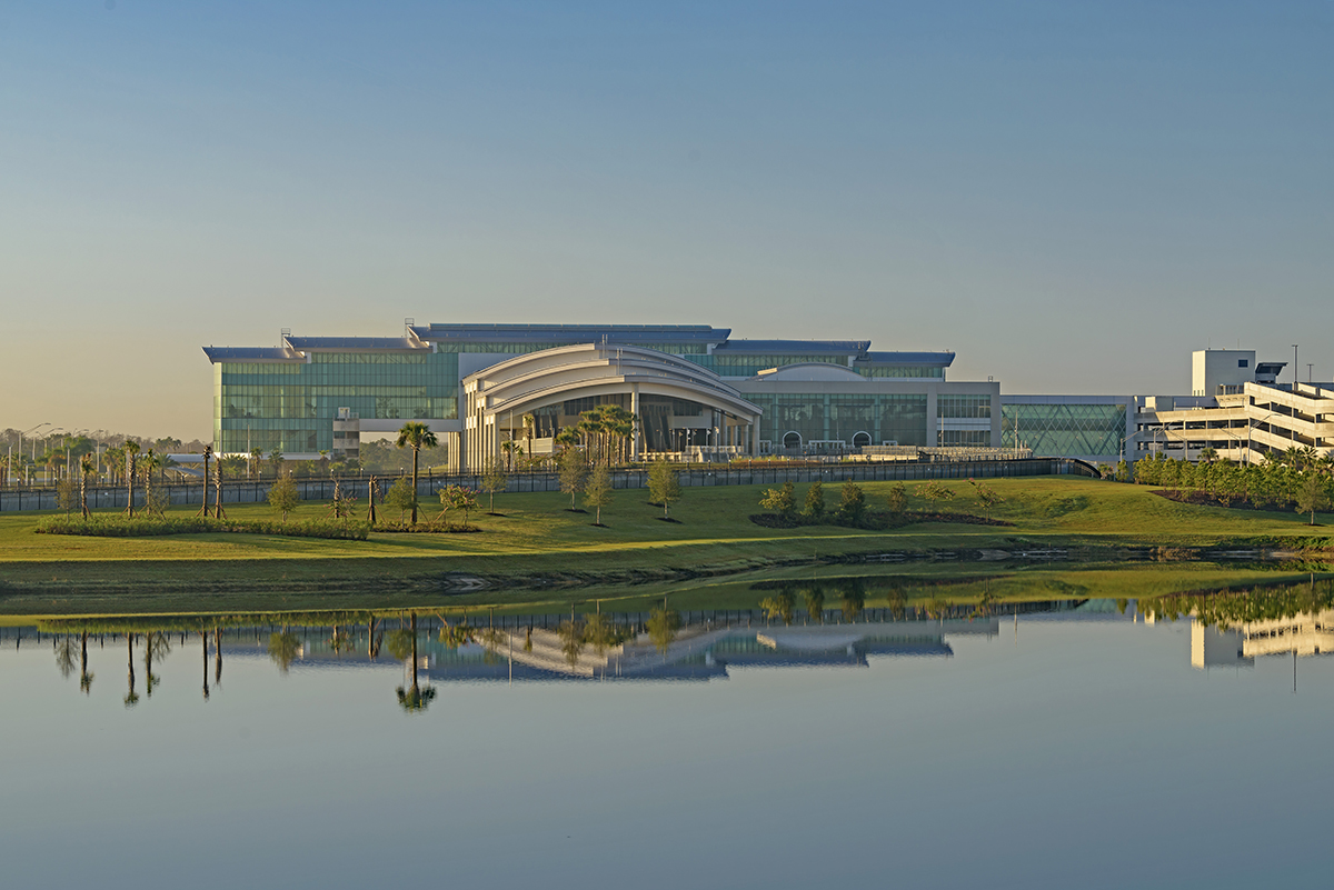 Outside looking at the front of Terminal C. A lake is in the foreground. Terminal C in background with blue skies.