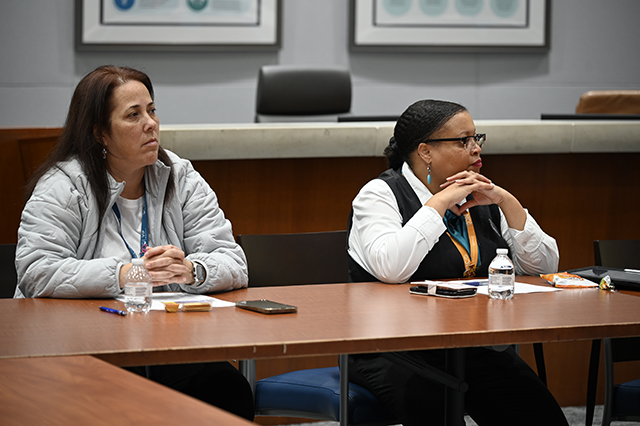 CSAC Culture Team - WORKSHOP Learn and Grow - Compassion Fatigue photo of two women GOAA employees at table listen intently to a speaker.