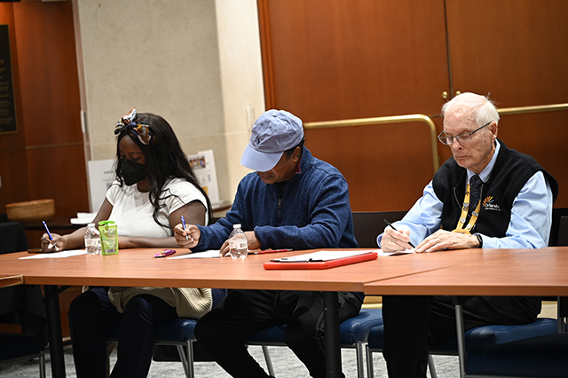 CSAC Culture Team - WORKSHOP Learn and Grow - Compassion Fatigue photo of three GOAA employees at a table taking notes.