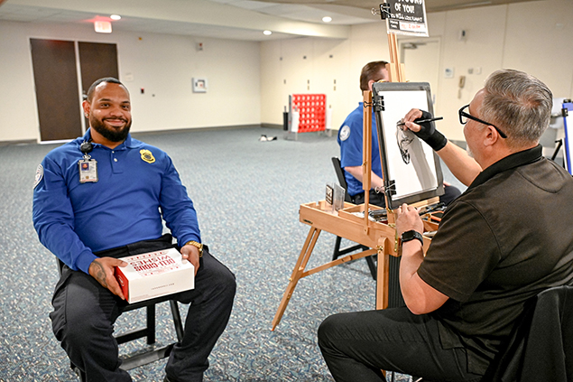 2025 Federal Airport Employee Appreciation Day photo of federal employee getting a caricature drawing done. 