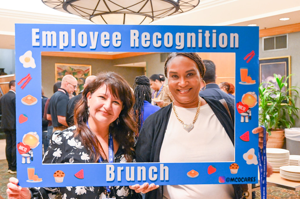 January 2024 Employee Recognition Brunch. Photo of two GOAA employees holding a large frame in front of them. The frame says, "It all starts with me!"