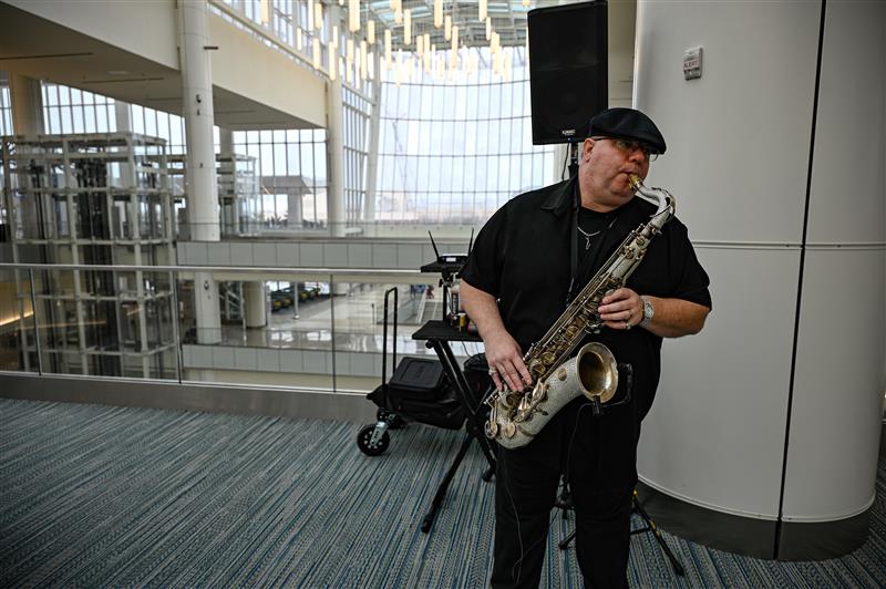 A man playing a saxophone at MCO Terminal C.