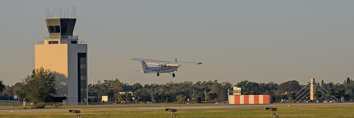 A single engine plane lands at ORL. In 1995, the FAA moved into a new Air Traffic Control Tower ideally located south and midfield of runway 7/25.