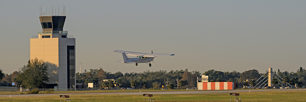 A single engine plane lands at ORL. In 1995, the FAA moved into a new Air Traffic Control Tower ideally located south and midfield of runway 7/25.