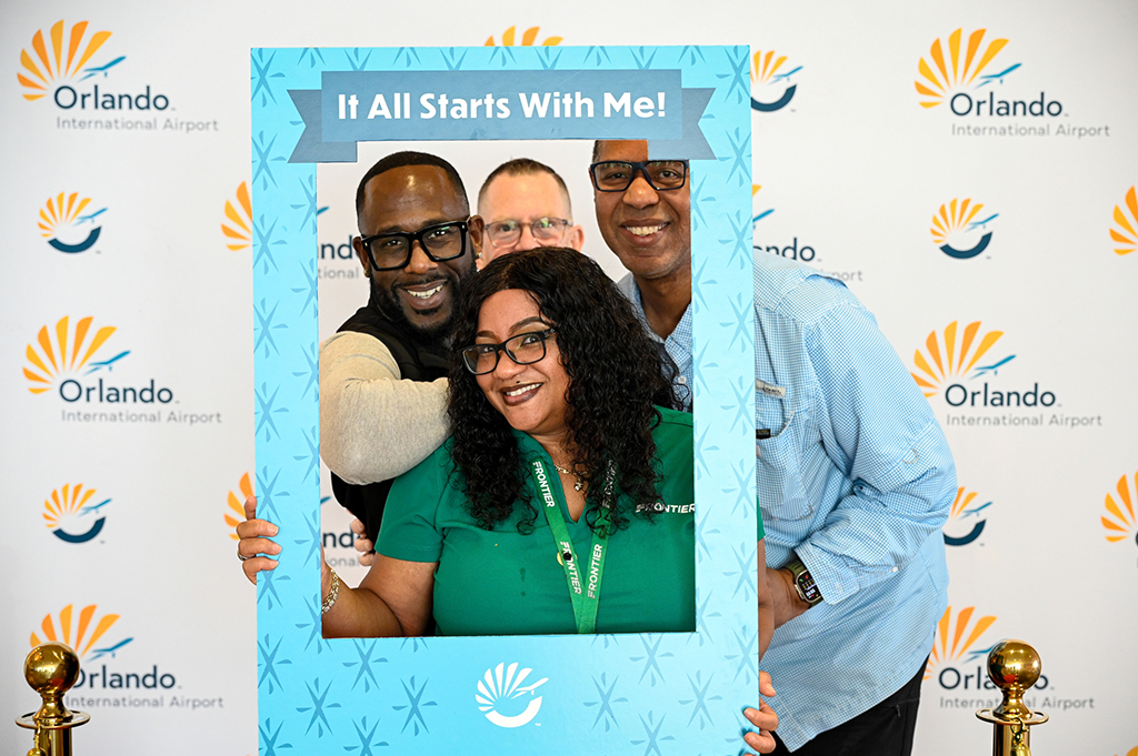 2025 Employee Recognition Brunch group photo of four employees posing behind a picture frame that says, "It all starts with me."