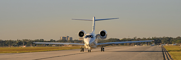 A corporate jet lands on the runway of Orlando Executive Airport.
